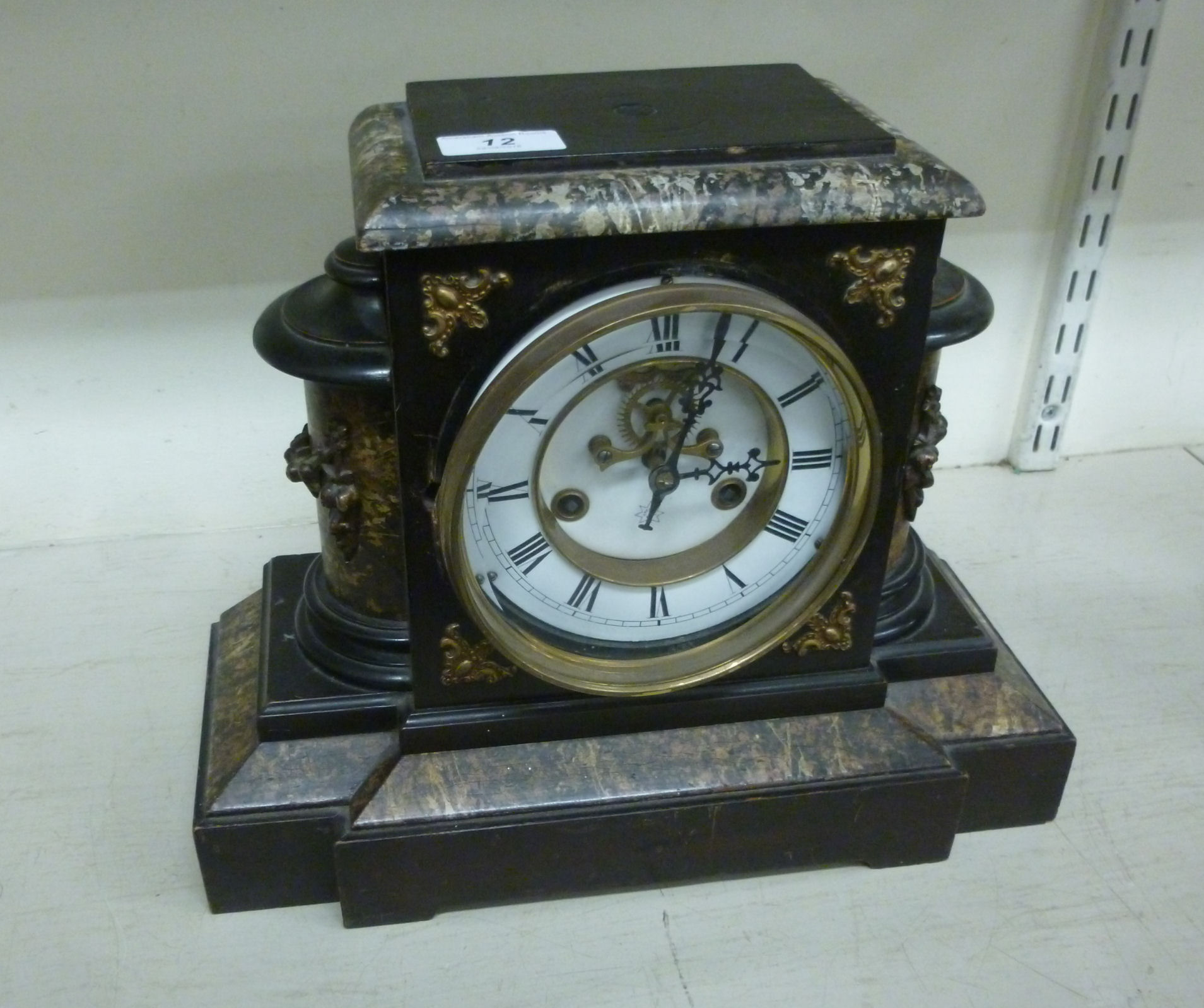 A late Victorian black painted breakfront mantel clock of architectural form;