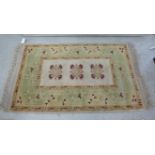 A Turkish rug with three medallions on a cream coloured ground 35'' x 58'' BSR