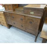 A 1930s oak sideboard with two drawers, flanked by a pair of doors, raised on barleytwist,