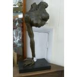 A cast and patinated bronze figure, a woman's torso, resting on her hand,