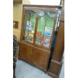 A modern mahogany finished display cabinet, having twin glazed doors,