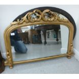Two mirrors: to include a late Victorian example, the arched plate set in a pierced and C-scrolled,