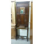 A 1920/30s oak hall stand, having six hooks and a central bevelled mirror,