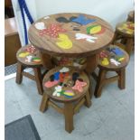 A child's carved and painted hardwood table 18''h 20''dia; and four matching stools,