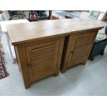 A pair of modern light oak bedside cabinets, each with a slatted door,