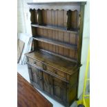 A modern Old English style oak dresser, the superstructure with two open shelves,