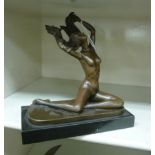 A cast and patinated bronze nude figure, a woman running her hands through her hair,