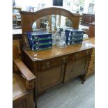 A mid 20thC stained oak sideboard, the superstructure set with an oval bevelled mirror,