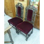 A pair of late Victorian carved oak framed dining chairs,