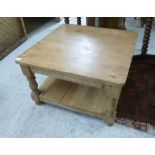 A modern waxed pine two tier coffee table, raised on ring turned,