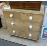 A late Victorian pine four drawer dressing chest with porcelain handles,