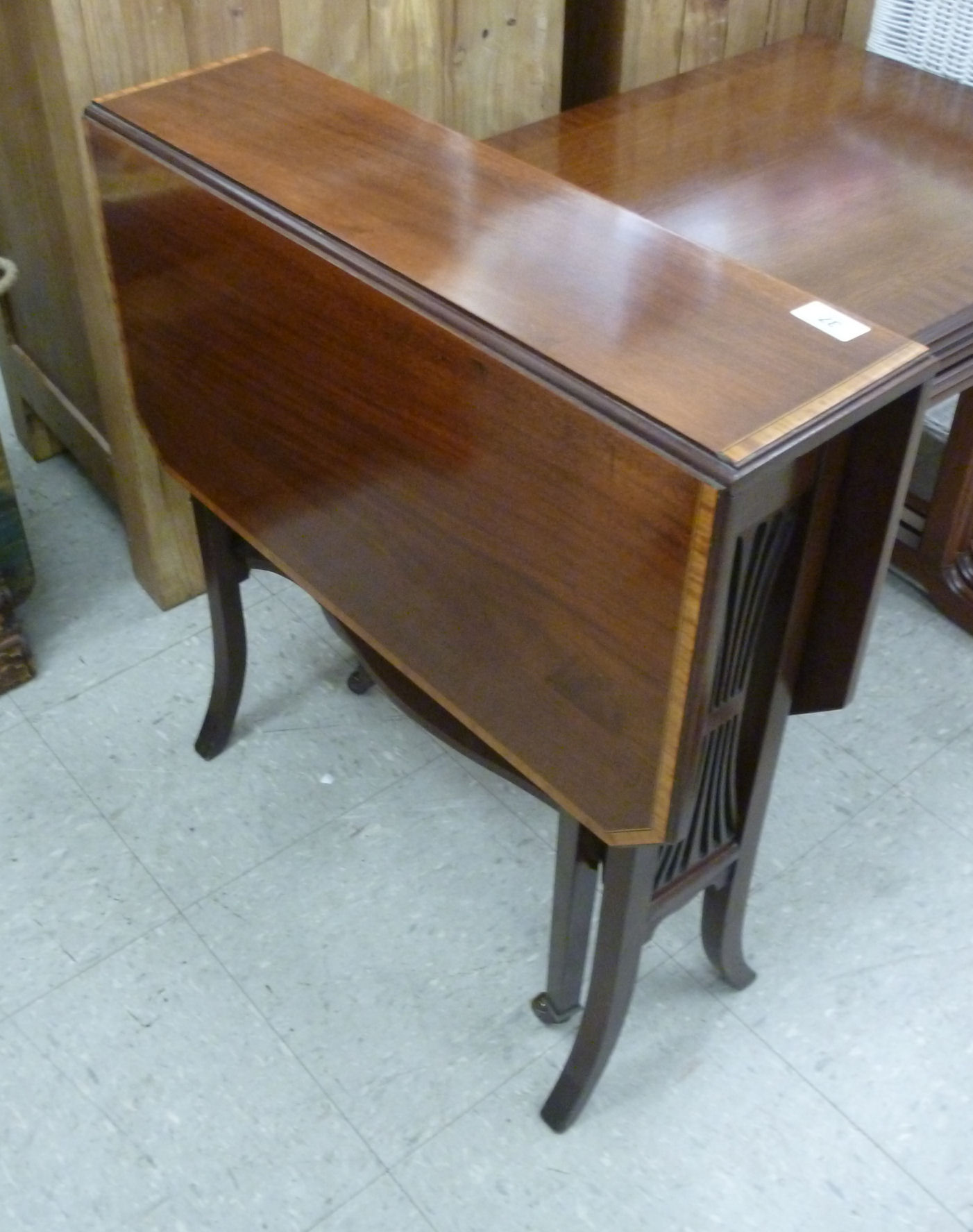 An Edwardian mahogany Sutherland table, the crossbanded top raised on square,