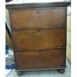 An early 20thC mahogany cabinet with three fall flaps, raised on turned,