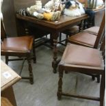 A 1930s oak draw leaf dining table, raised on turned,