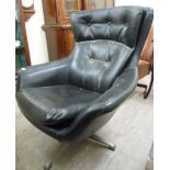 A 1960s arm chair, part button upholstered in black vinyl, raised on chromium plated,