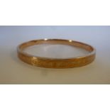A 9ct gold hollow bangle with cast ornament