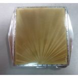 An Art Deco silver and gold coloured enamel powder compact with sunburst, engine turned decoration,