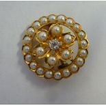 A gold coloured metal rosette design brooch, set with a central diamond,