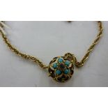 A yellow metal pendant, set with a central diamond in a turquoise bead surround,