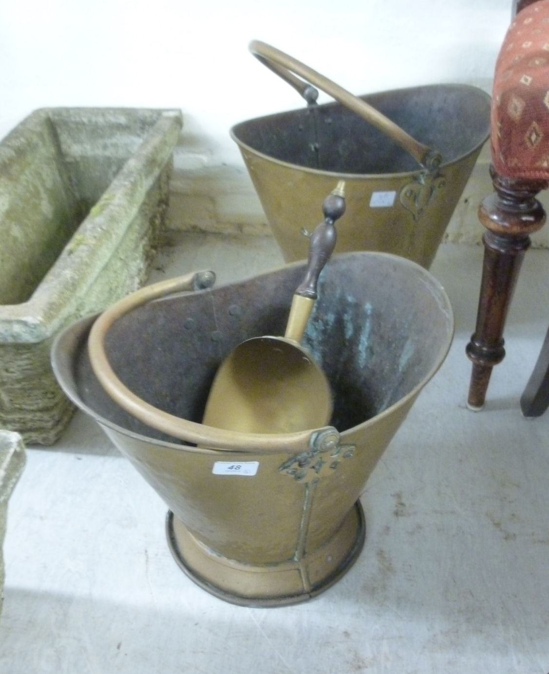 Two late Victorian brass helmet shaped coal scuttles with swing top handles,