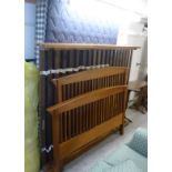 A modern teak bedstead with arched, railed ends,