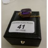 A 9ct gold pendant, set with an amethyst coloured stone,