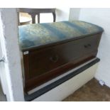 An Edwardian mahogany box ottoman with a patterned blue fabric upholstered top, over a deep drawer,