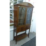 A 1920s satinwood string inlaid and crossbanded mahogany display cabinet with a low,