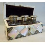 An early/mid 20thC mother-of-pearl clad miniature casket, the domed hinged lid enclosing three,