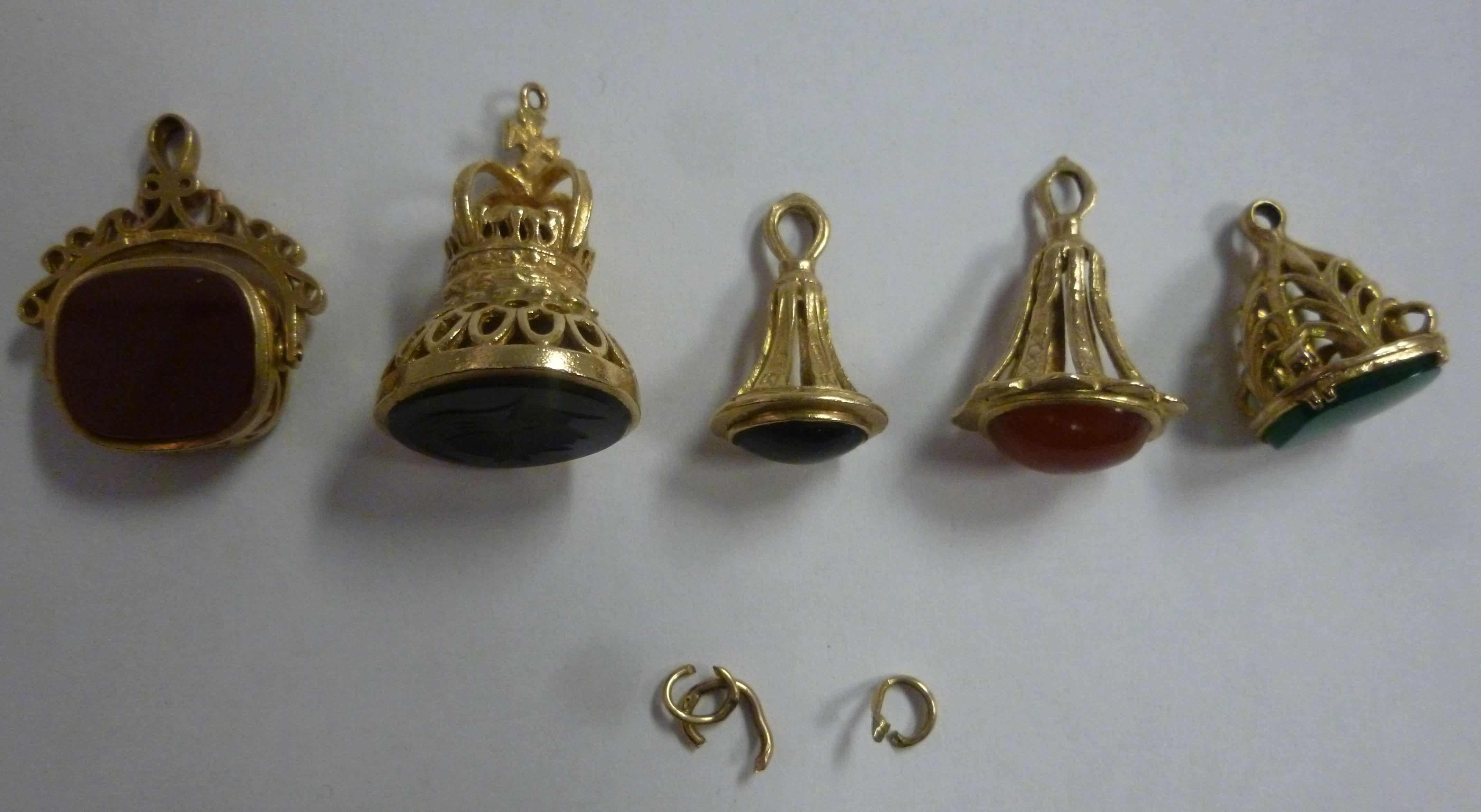 Four yellow metal pendant seals, variously set with coloured stones,