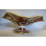 A Royal Crown Derby bone china wavy edged comport, elevated on a petal bordered pedestal foot,