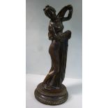 An early 20thC cast and patinated bronze figure, a partially robed, standing classical maiden,