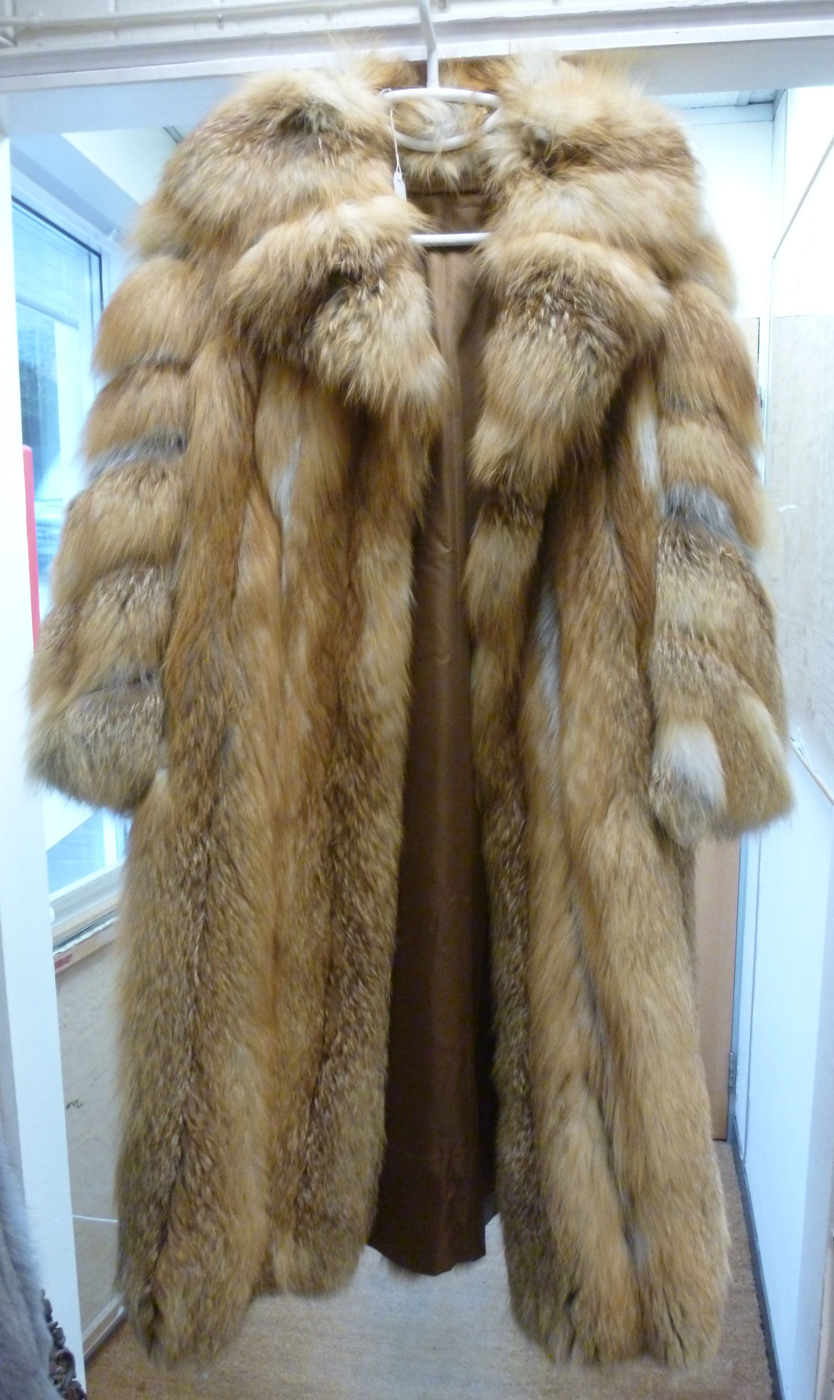 A two tone red fox fur coat with a lapel collar