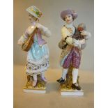 A pair of late 19thC German porcelain standing figures, he wearing a topcoat and breeches,