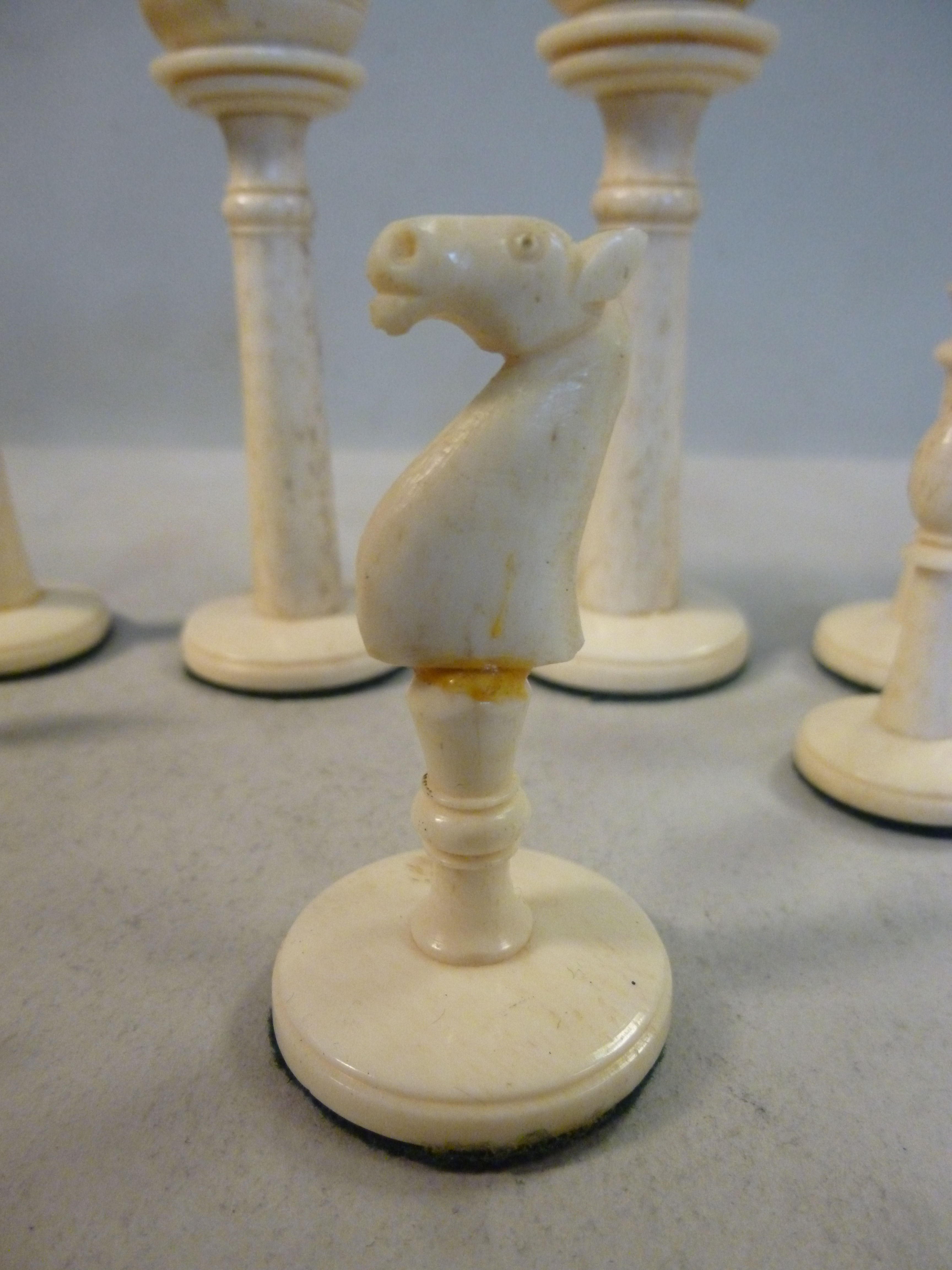 An early 20thC turned and carved bone, naturally coloured and black lacquered chess set, - Image 8 of 8