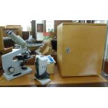 A modern USSR made grey enamelled steel binocular microscope, in a lockable,