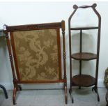A 1920s carved mahogany firescreen, set with a needlework panel,