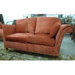 A modern, traditionally styled, two person settee, having a slightly arched, angled back and high,