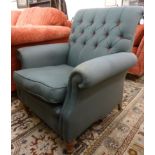 A modern armchair, having a scrolled back and level arms,