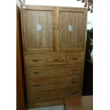 A 1930s limed oak compactum, having a pair of panelled doors,