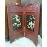 An early 20thC Japanese red lacquered, two fold screen,