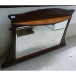 An Edwardian mahogany overmantel mirror with a single shelf,