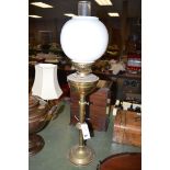 A Victorian brass oil lamp with milk glass shade.