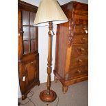 A turned mahogany standard lamp, fitted cream silk shade.