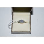 A tanzanite and diamond ring, the oval facet cut tanzanite flanked by diamonds in marquise mounts,