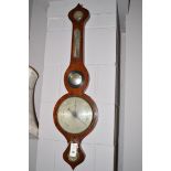 An antique mahogany wheel barometer and thermometer.