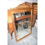 A modern rectangular bevelled wall mirror, within a gold painted frame decorated with scrolls,