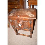 A mid 20th Century oak side cabinet, fitted a pair of carved panel doors,