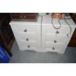 Two white coloured bedside tables, each with three drawers and metal handles,