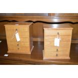 A pair of light stained wood specimen drawers, each with five drawers fitted brass drop handles.